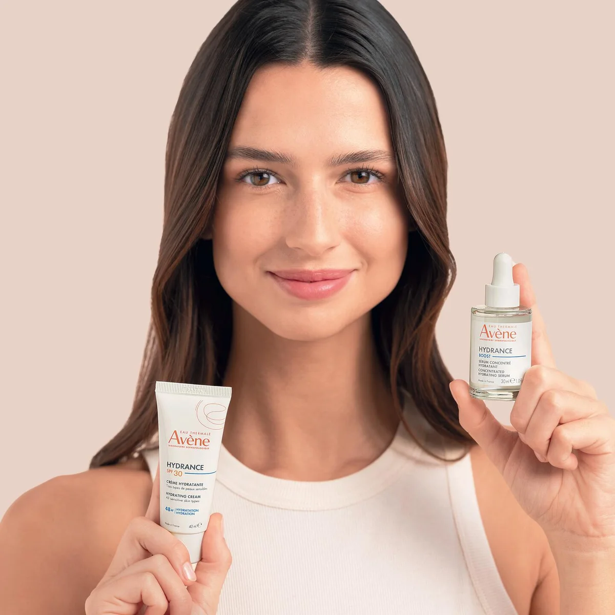 Photographie Avène : une femme présente une crème et un sérum Hydrance.